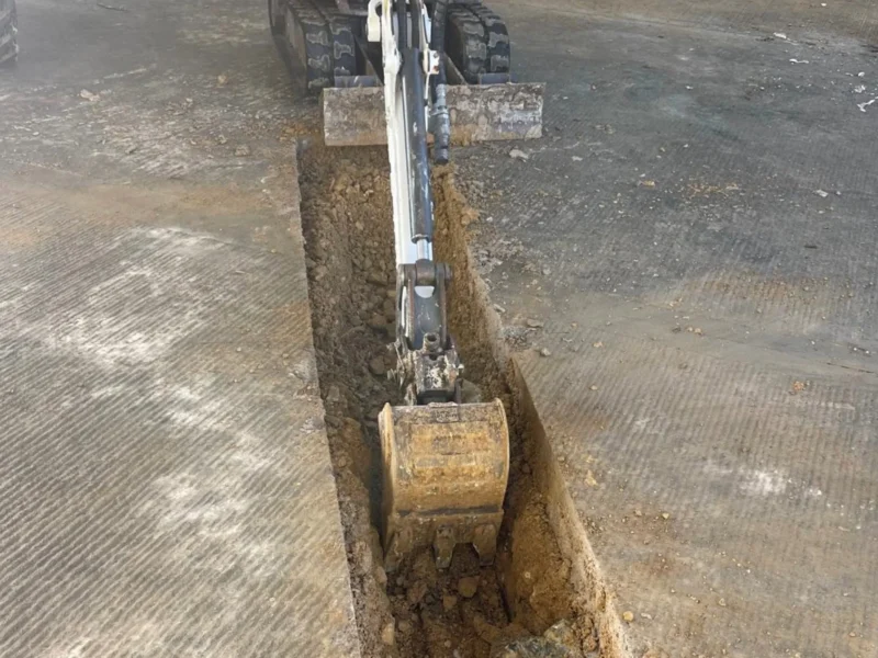 A scooper digging a small trench.